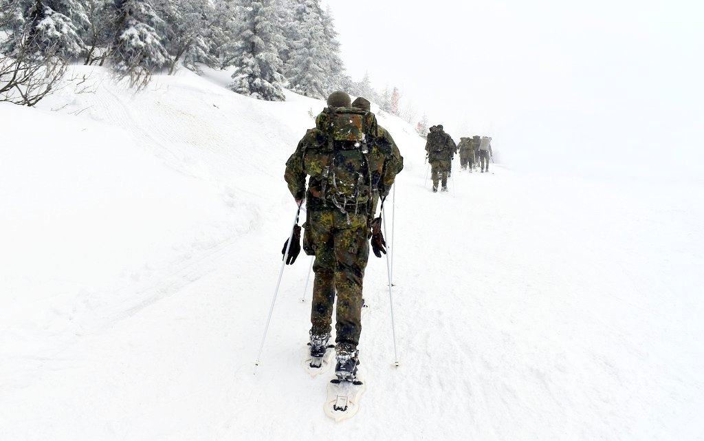 Voják na sněhu se sněžnicemmi. Paradox klouzavého sněhu a přesto pevné půdy pod nohama. / -ima-
