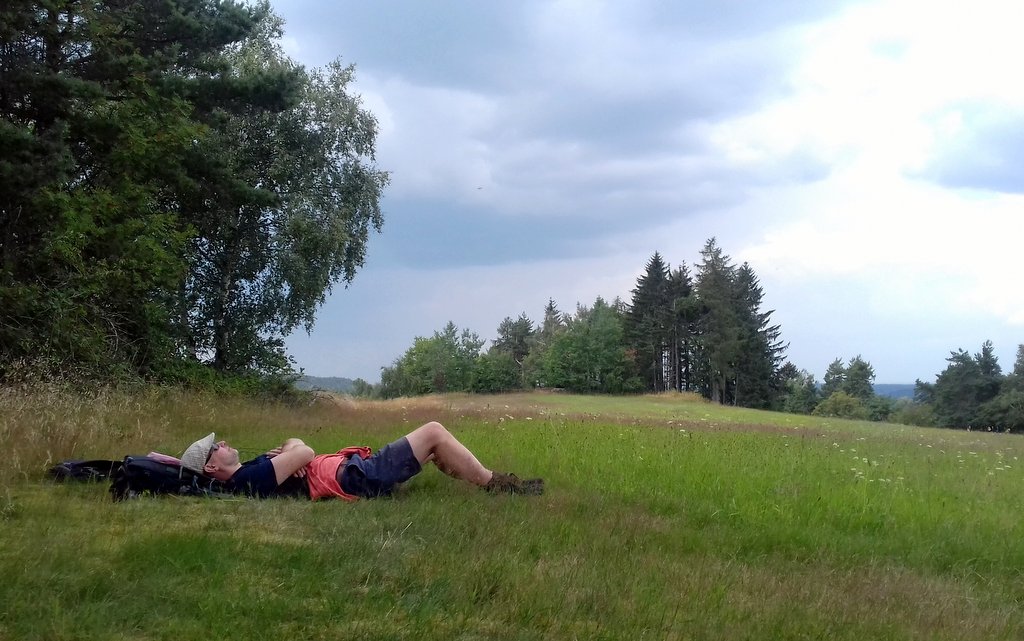 člověk ležící v trávě na louce u lesa, odpočinek spánek, obloha / foto -AM-