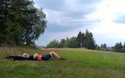 člověk ležící v trávě na louce u lesa, odpočinek spánek, obloha / foto -AM-