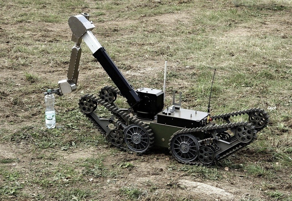 láhev vody, robto, technologie / foto -ima- / komentář obrázku: Uprostřed technického a chladného světa se objevuje voda – základ života. Tak i v našem nitru tiše proudí Boží Duch, který zavlažuje poušť duše.